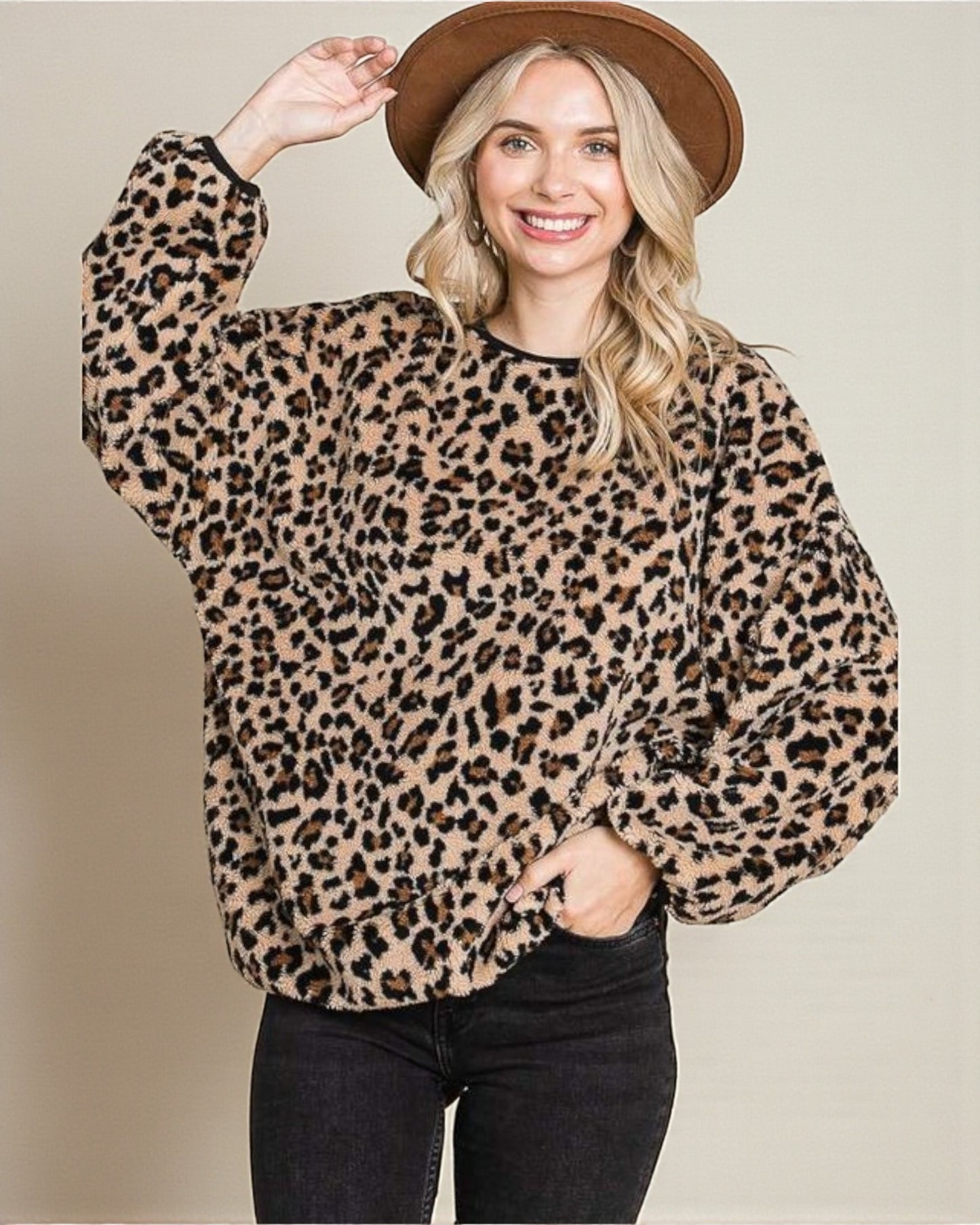 Woman wearing a leopard print sweater and brown hat on a beige background