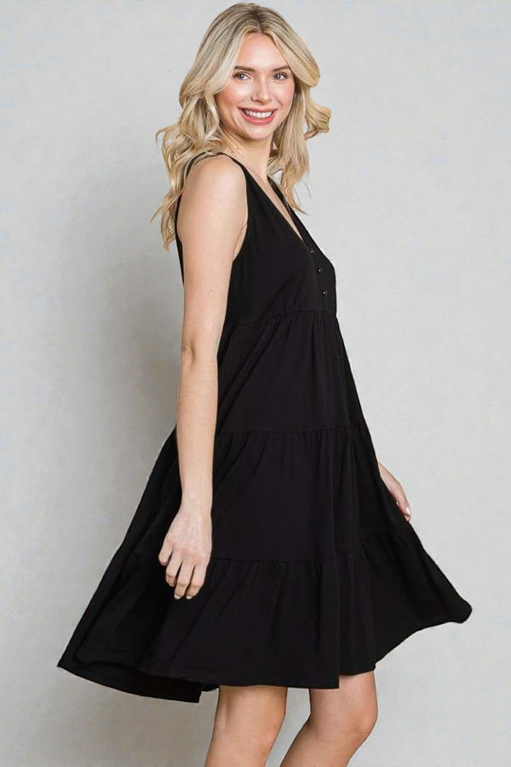 Woman wearing a black dress against a plain background