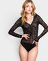 Woman wearing a black sheer long-sleeve bodysuit on a white background