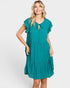 A woman modeling a teal green tiered midi dress with short flutter sleeves, a split neckline with a keyhole tie, and side pockets, set against a plain light gray background.