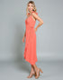 Woman wearing a coral dress on a gray background