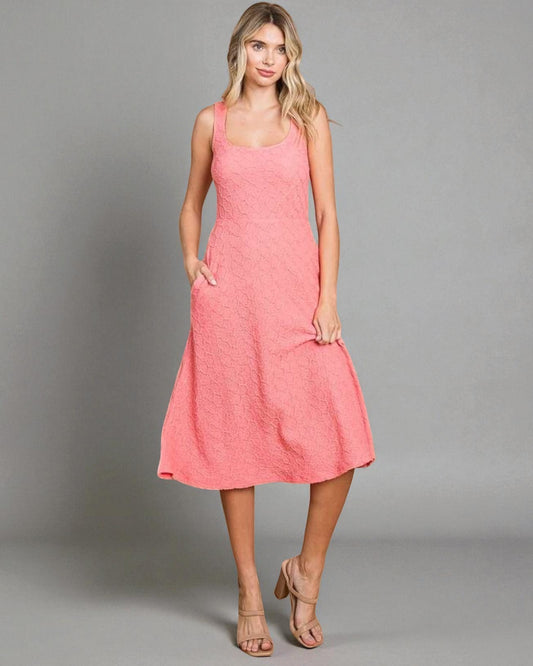 Woman wearing a pink dress against a gray background