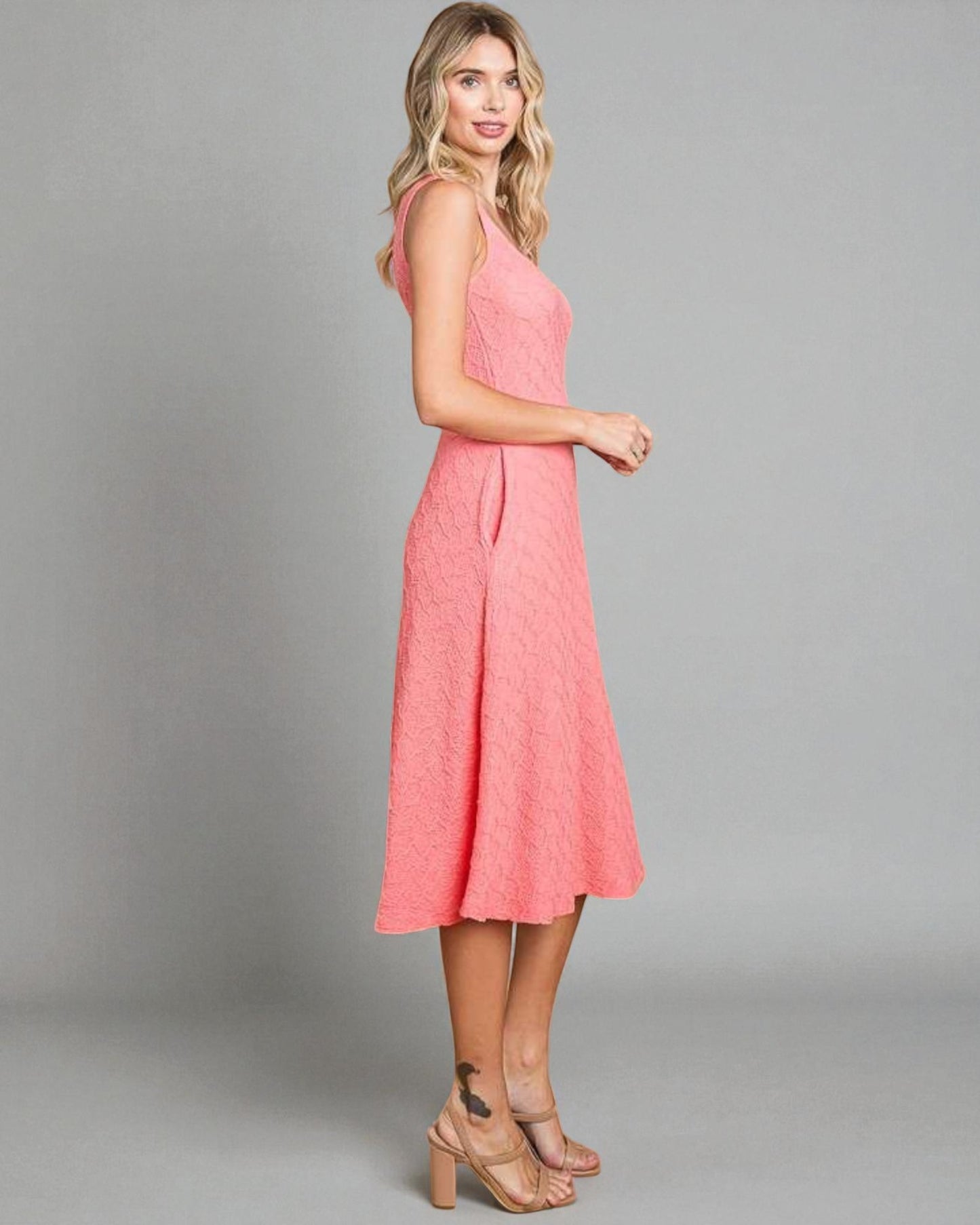 Woman wearing a pink dress against a gray background