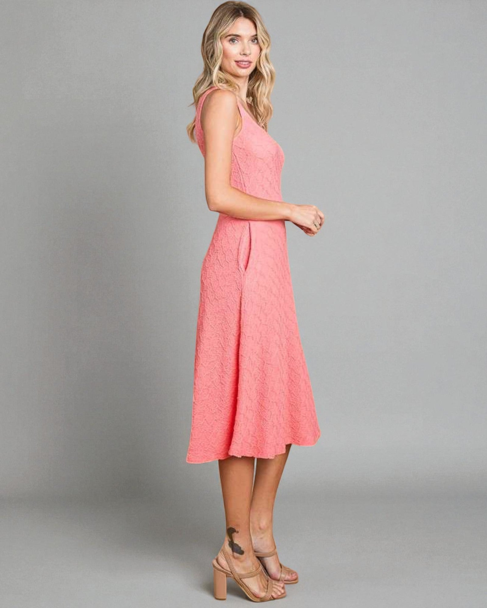 Woman wearing a pink dress against a gray background