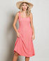 Woman wearing a pink dress and straw hat against a plain background