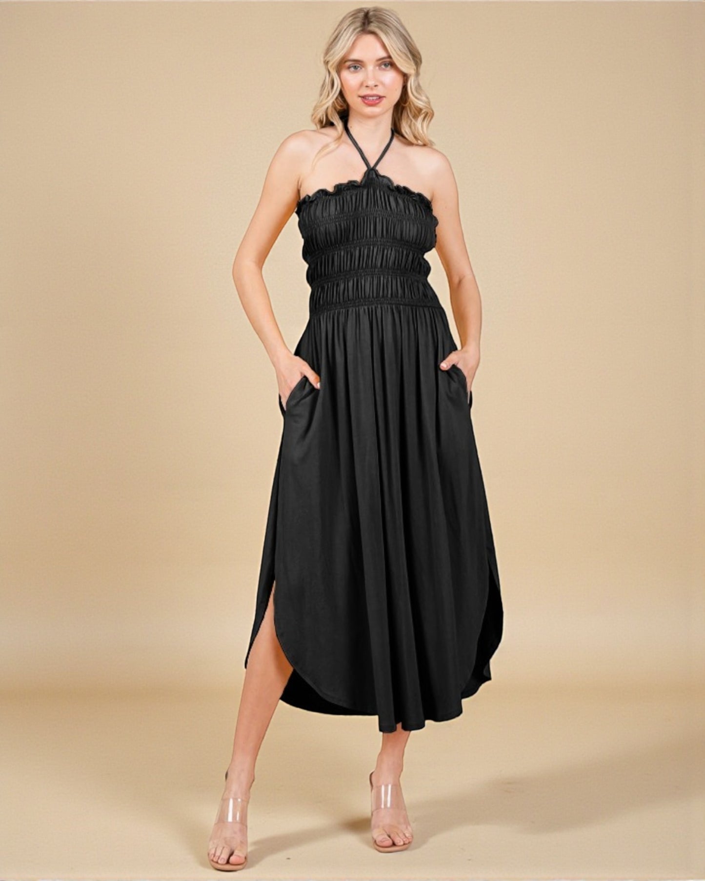 Woman wearing a black halter neck dress on a beige background