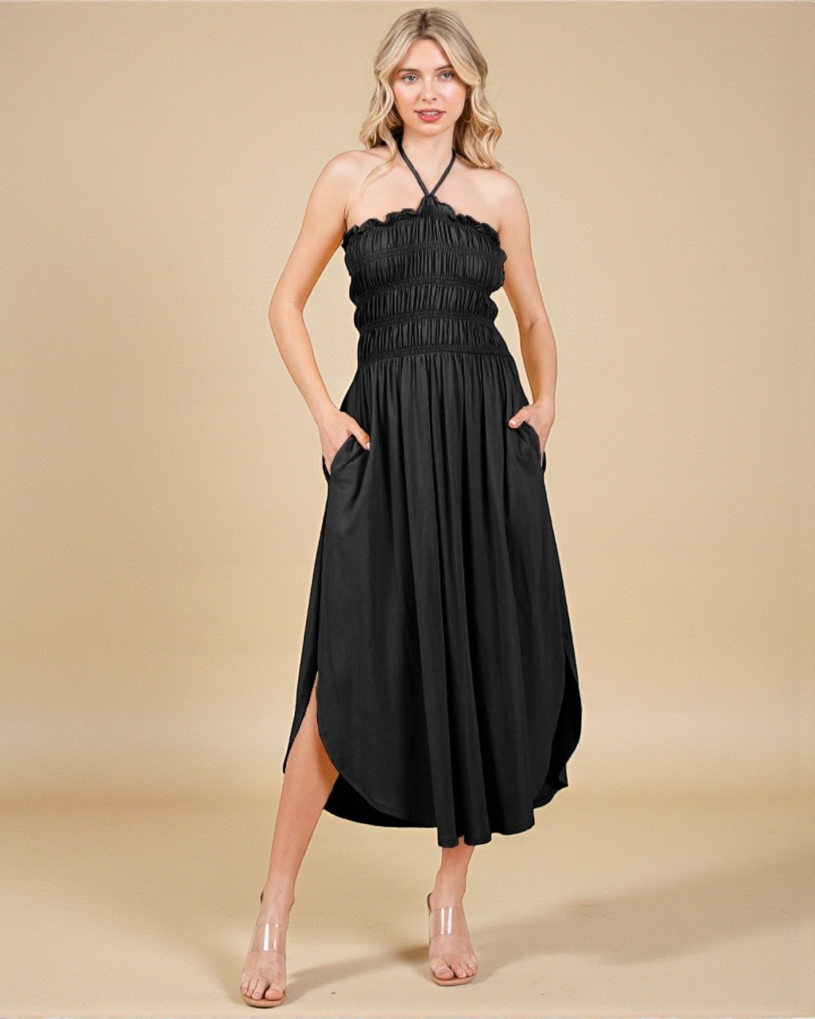 Woman wearing a black halter neck dress on a beige background