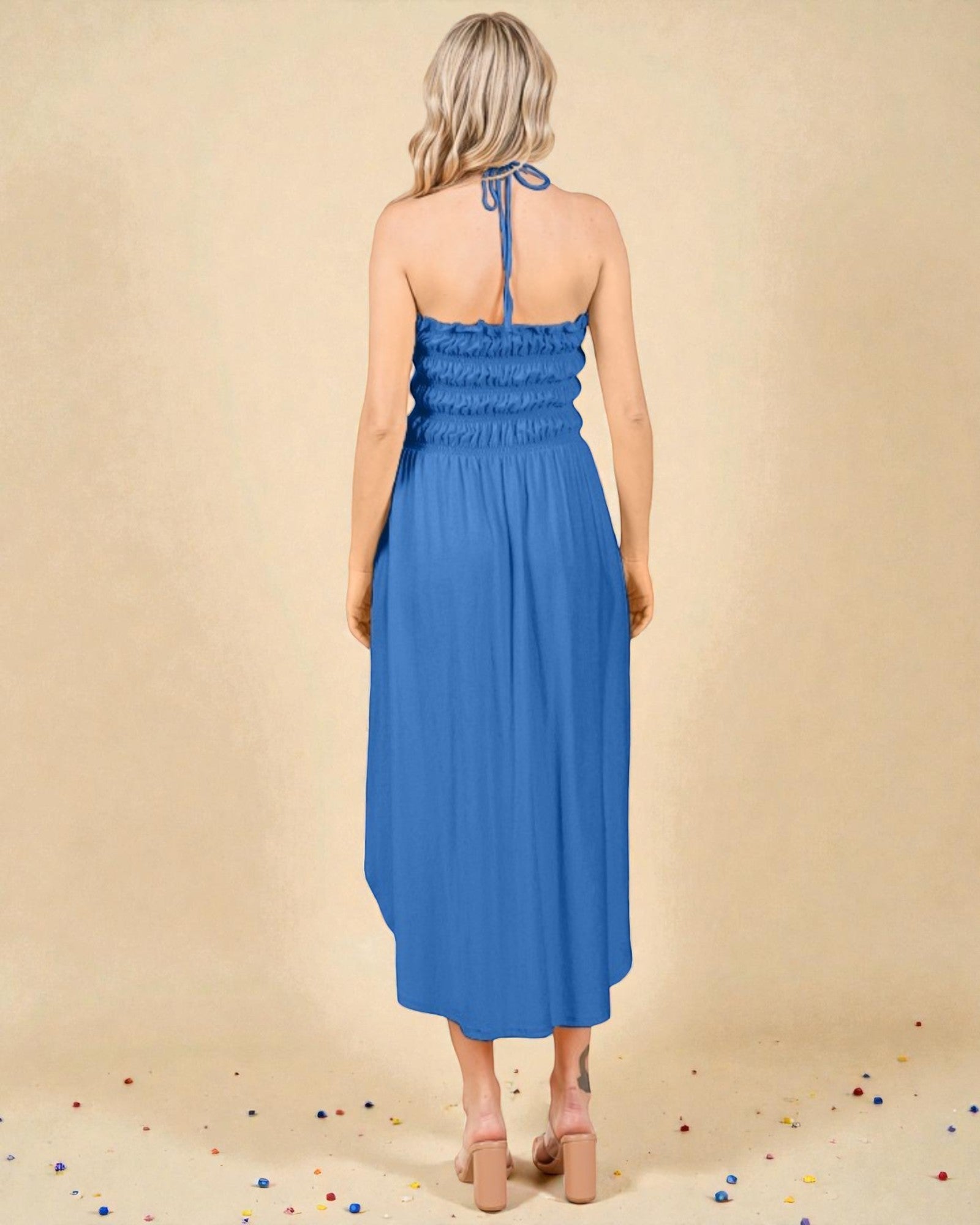 Woman wearing a blue dress against a beige background