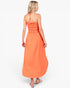 A woman modeling a bright orange strapless maxi dress with a smocked bodice, shown from the back against a plain white studio background.