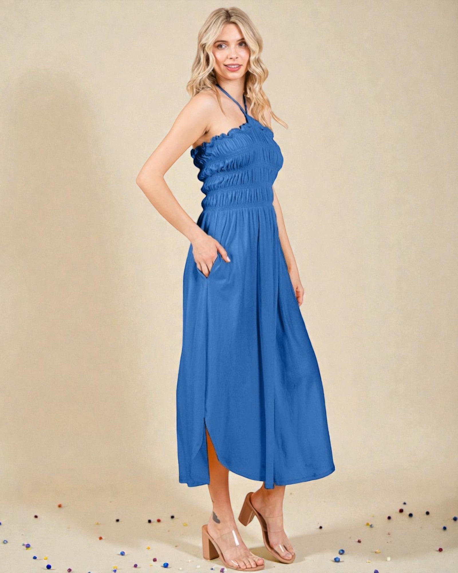 Woman wearing a blue dress against a beige background