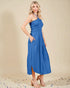 Woman wearing a blue dress against a beige background