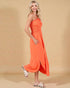 Woman wearing an orange halter neck dress on a beige background
