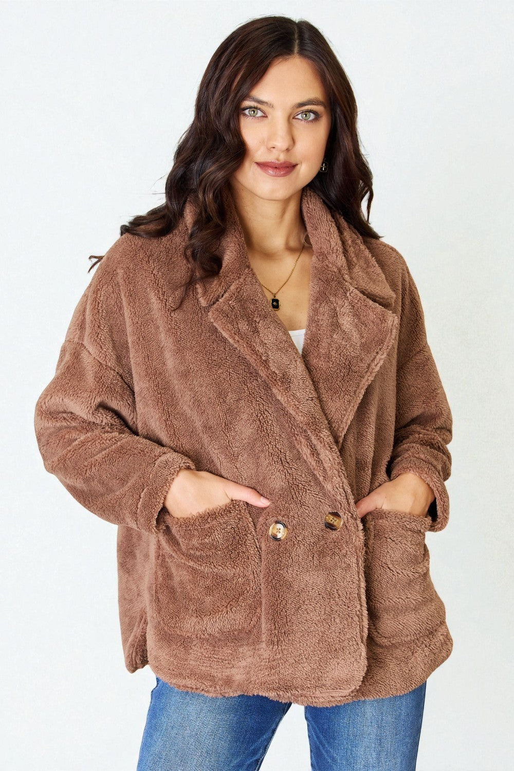Woman wearing a brown teddy coat on a white background