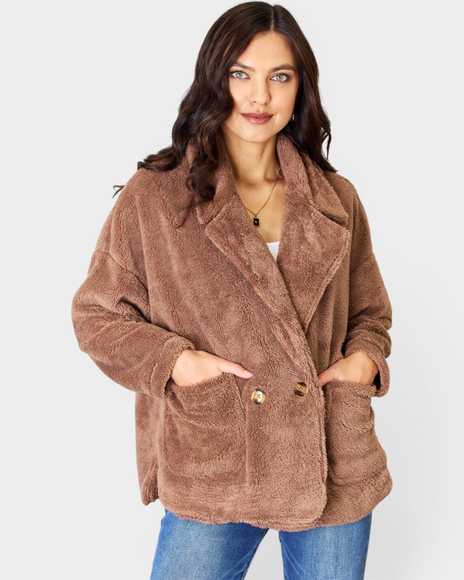 Woman wearing a brown teddy coat on a white background