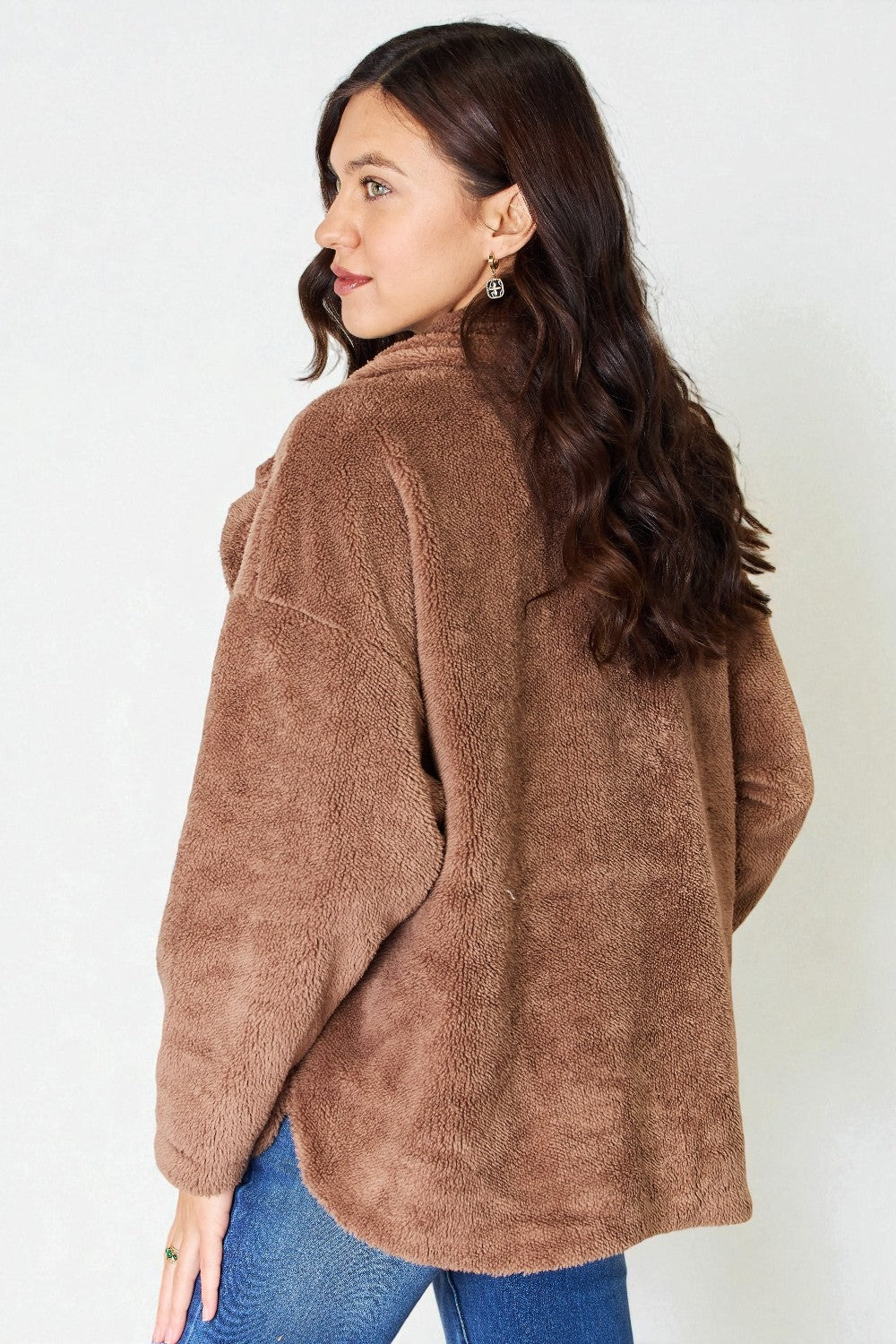 Woman wearing a brown fleece jacket against a white background