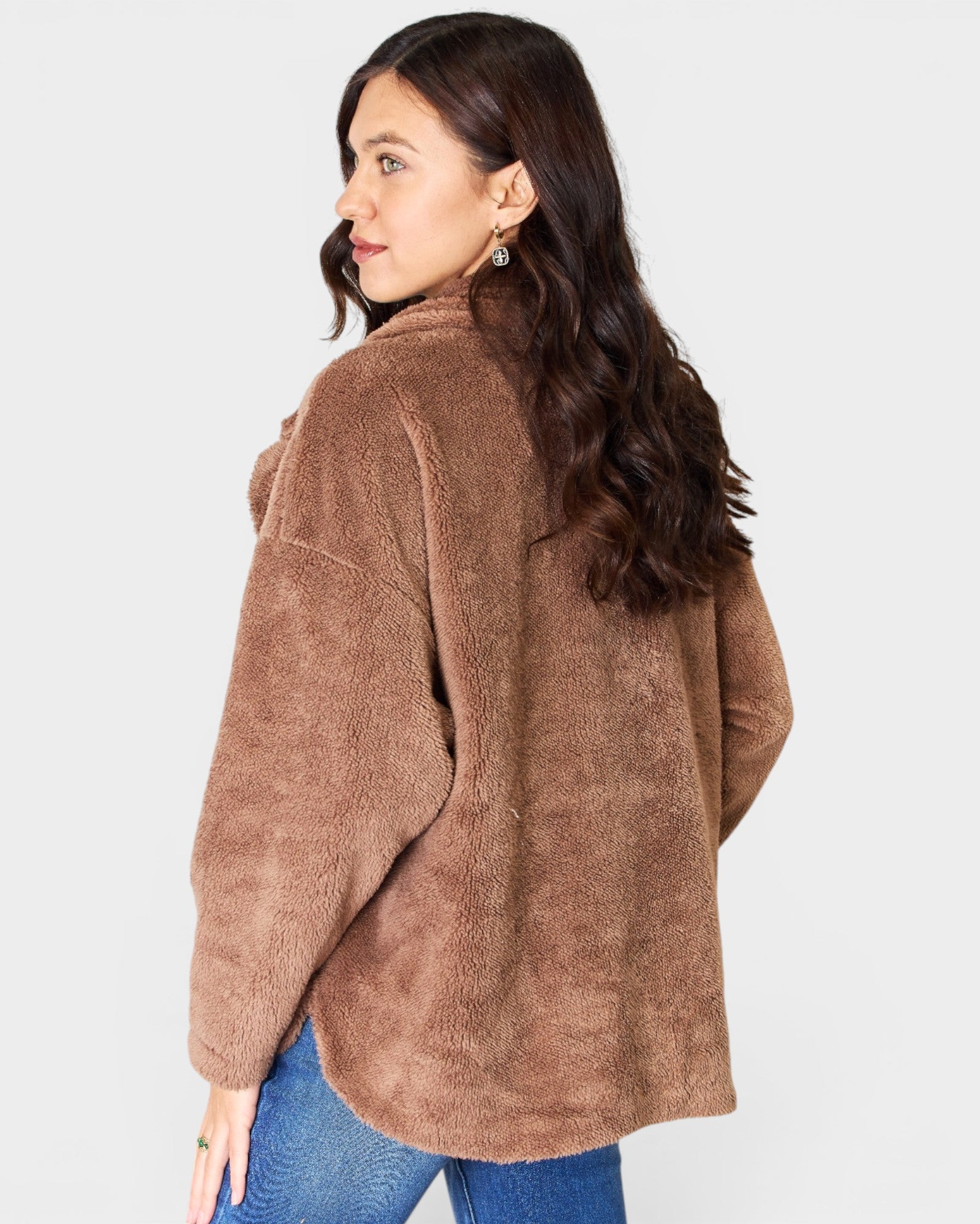 Woman wearing a brown teddy coat on a white background