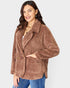 Woman wearing a brown sherpa jacket on a white background