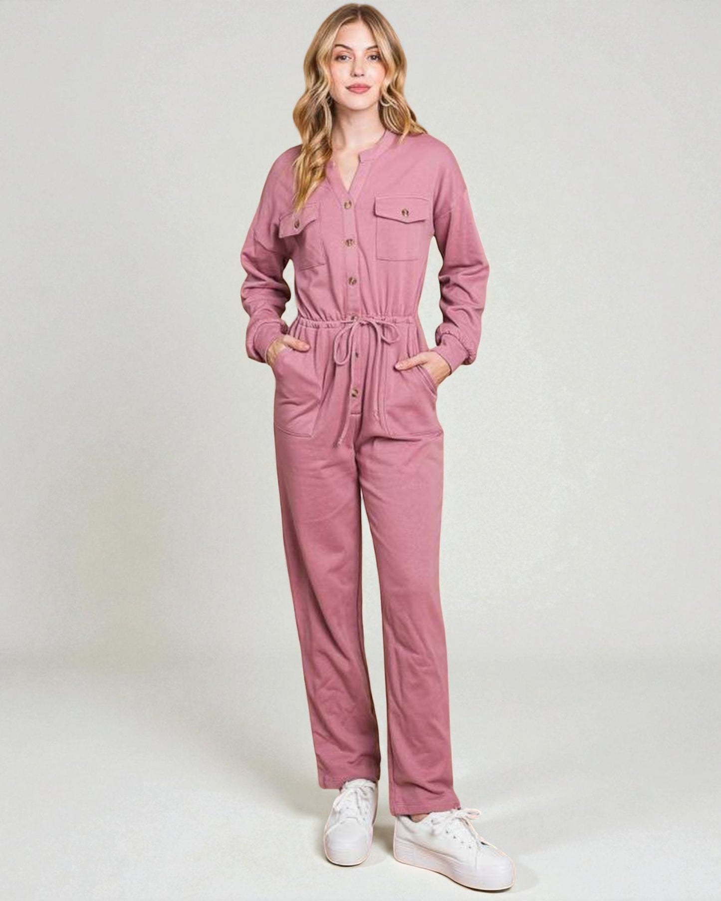 Woman wearing a pink jumpsuit on a white background