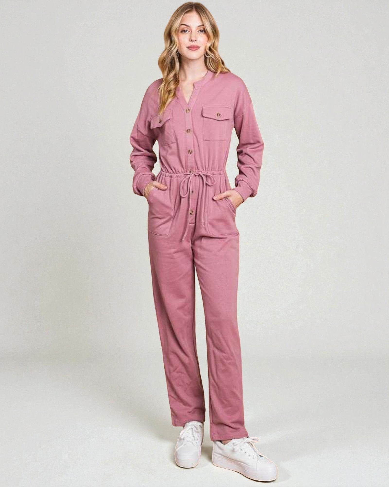 Woman wearing a pink jumpsuit on a white background