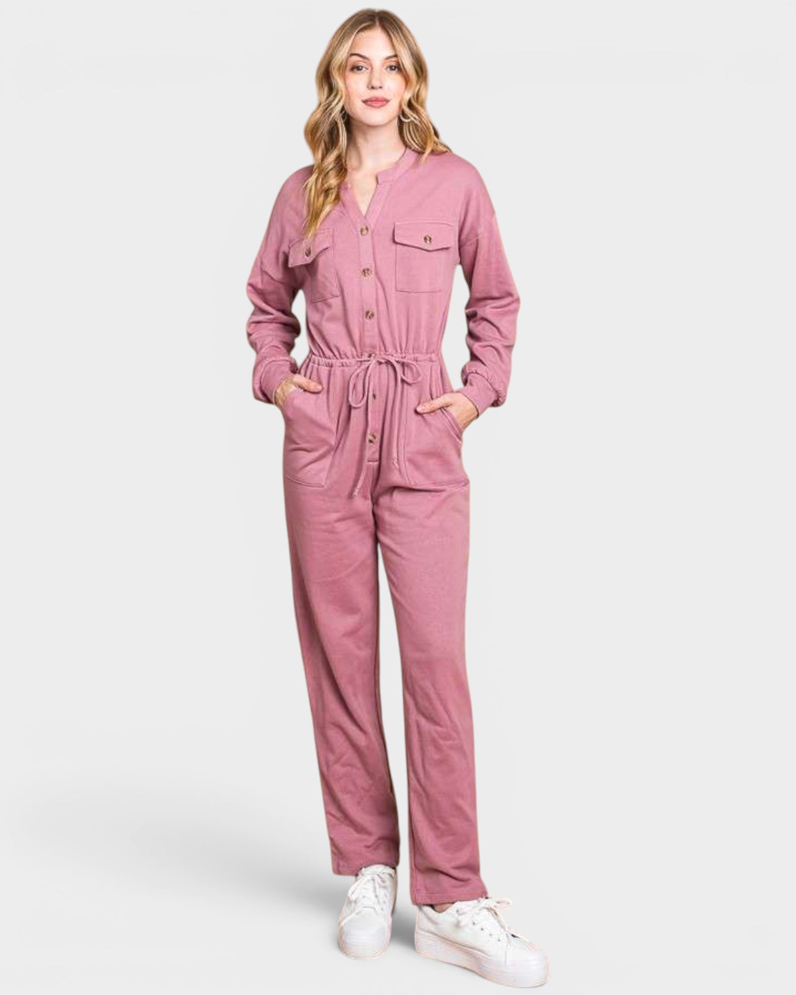 Woman wearing a pink jumpsuit on a white background