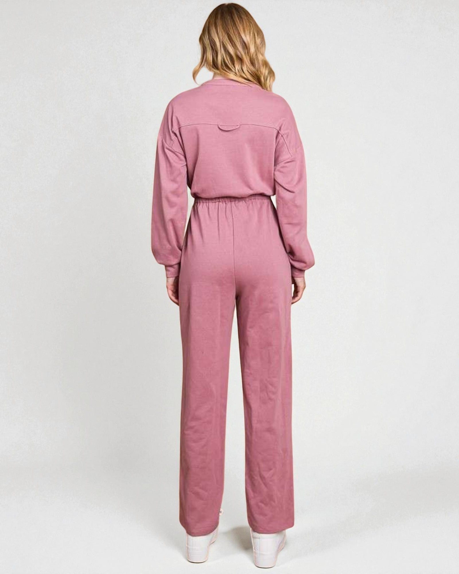 Pink jumpsuit worn by a person on a white background