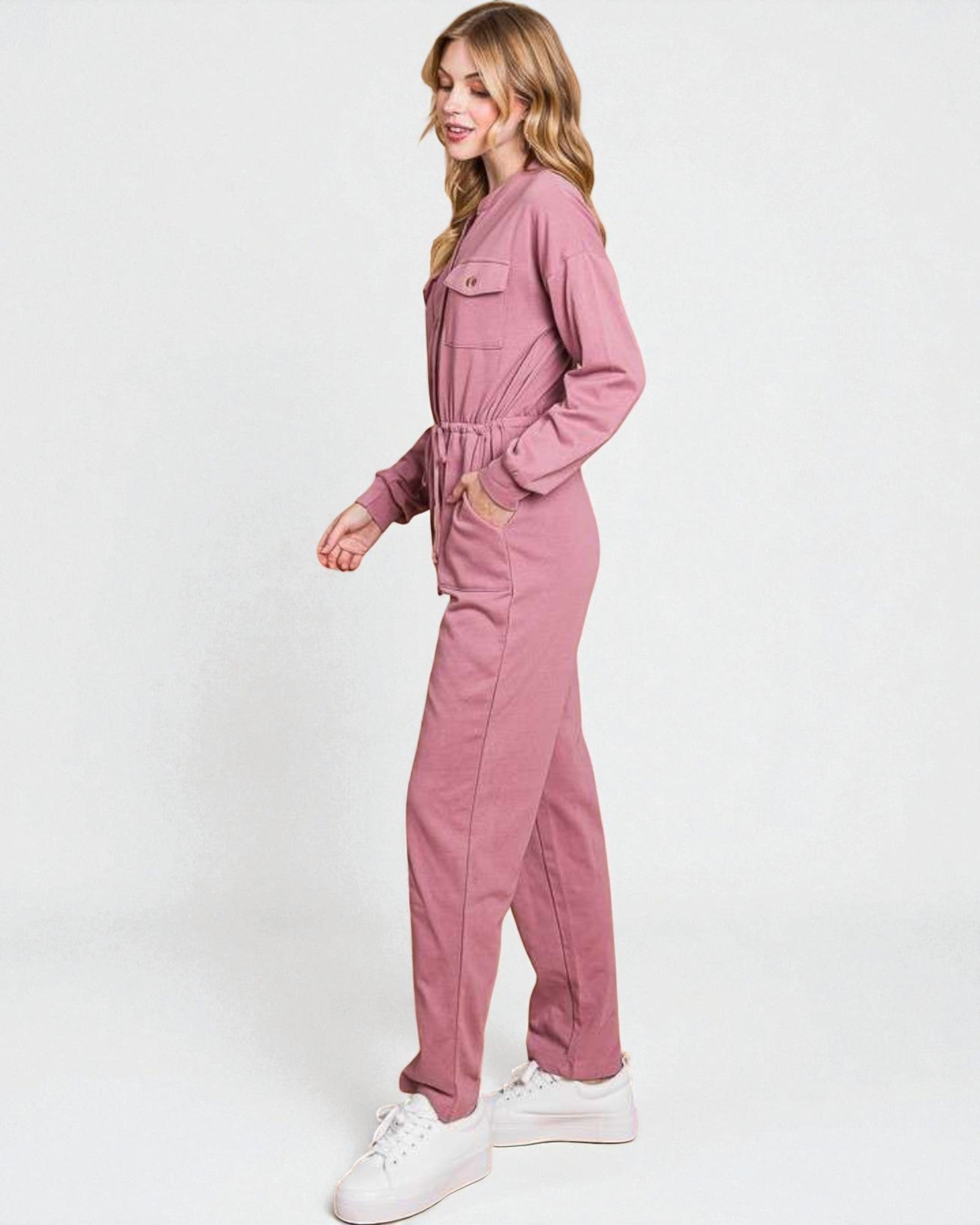 Woman wearing a pink jumpsuit on a white background