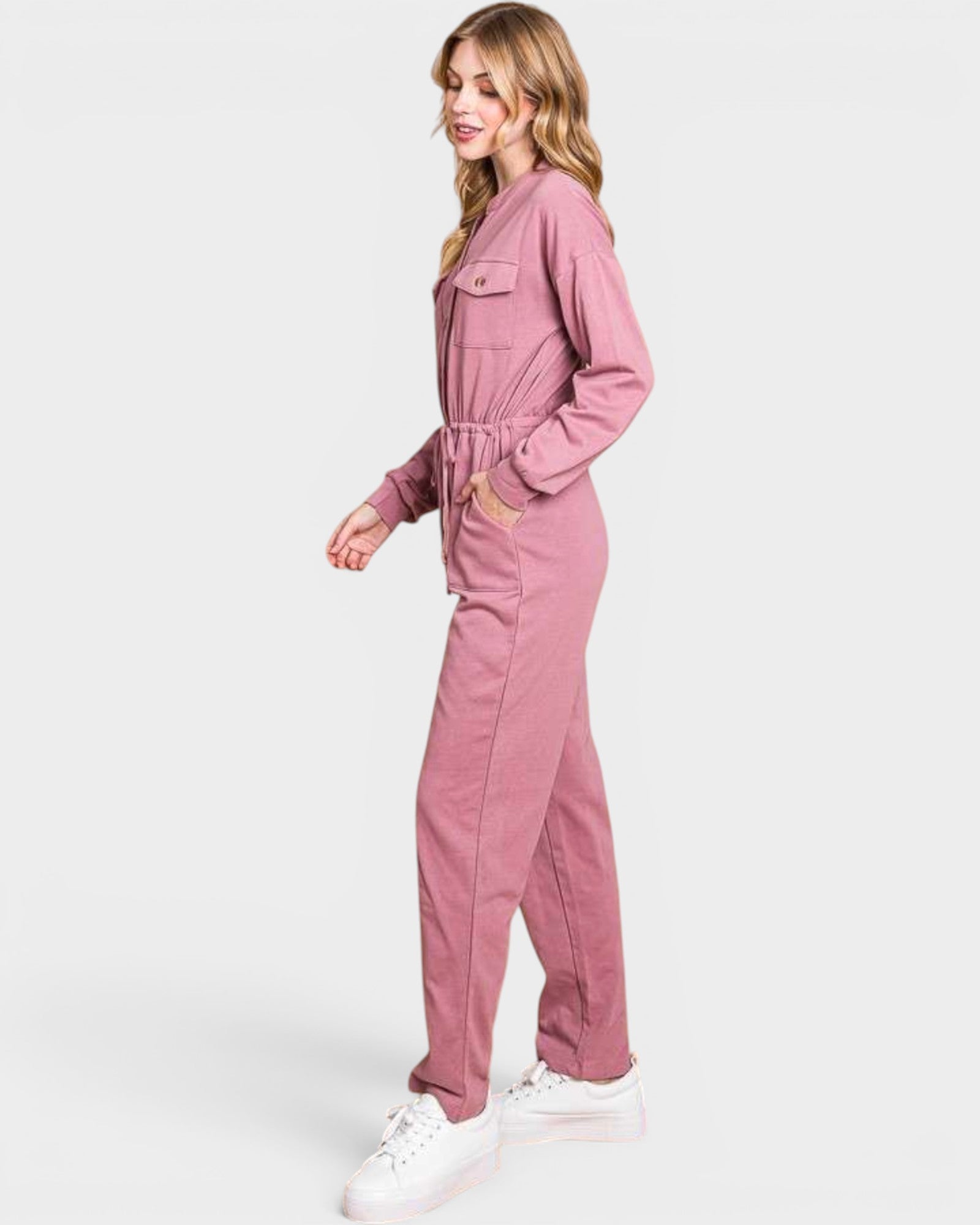 Woman wearing a pink jumpsuit on a white background