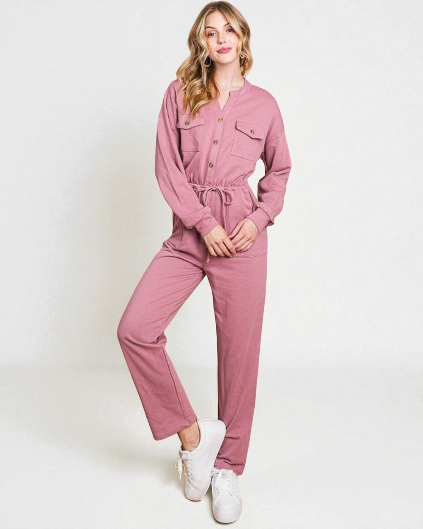 Woman wearing a pink jumpsuit on a white background