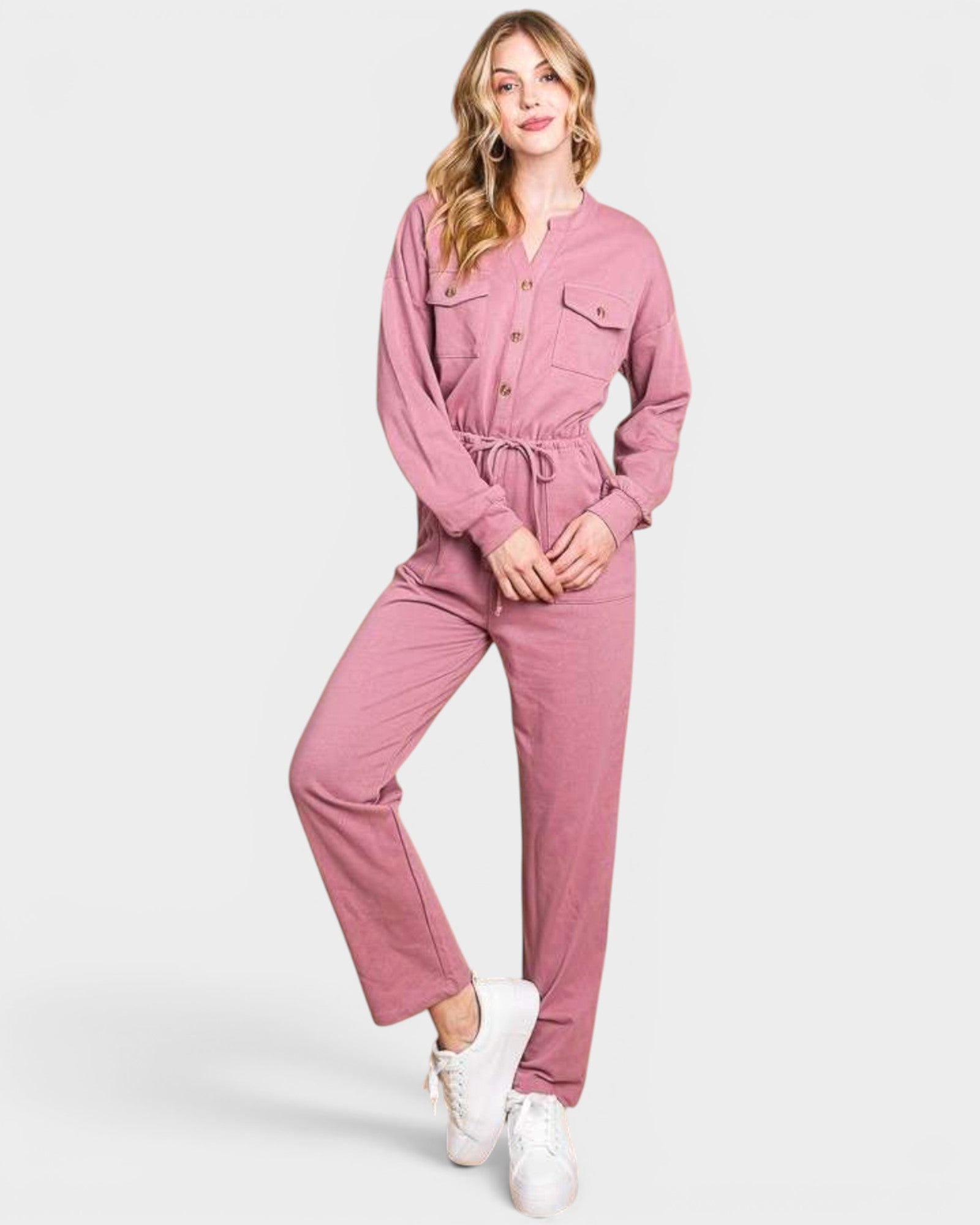 Woman wearing a pink jumpsuit on a white background