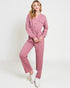Woman wearing a pink jumpsuit on a white background