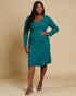 Woman wearing a teal dress against a beige background