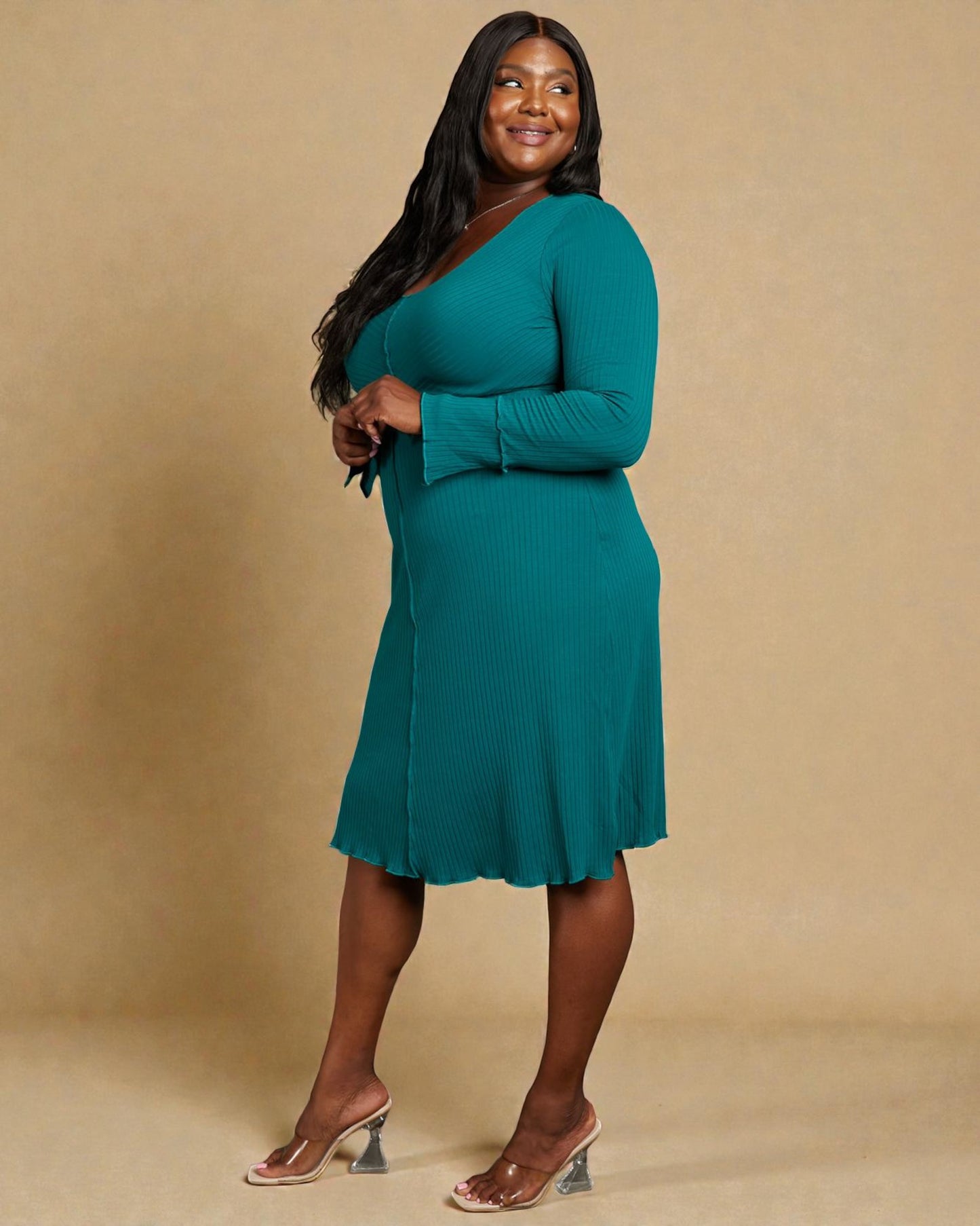 Woman wearing a teal dress against a beige background