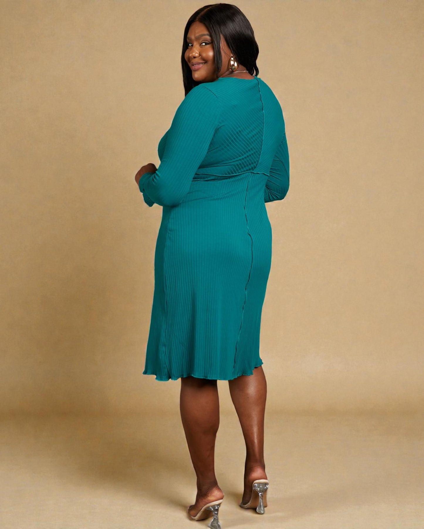 Woman wearing a teal dress against a beige background