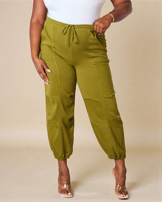 Person wearing green pants on a beige background