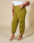 Person wearing green cargo pants on a beige background