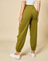 Person wearing green jogger pants on a beige background
