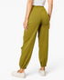 A model wearing olive green jogger-style pants with side cargo pockets, shown from the back against a clean white background.