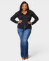 Woman wearing a black long-sleeve top and blue jeans on a white background
