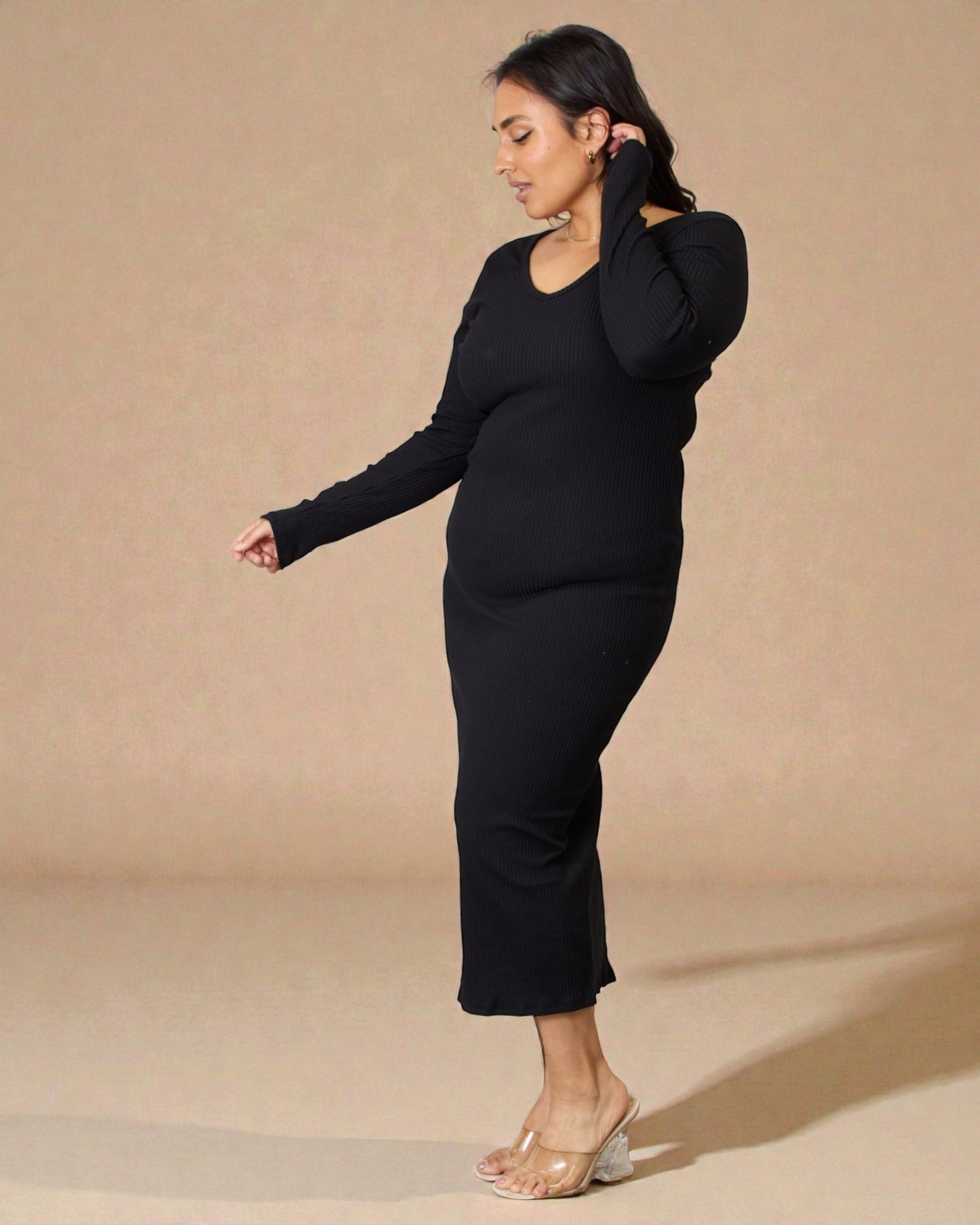 Woman wearing a black outfit against a beige background