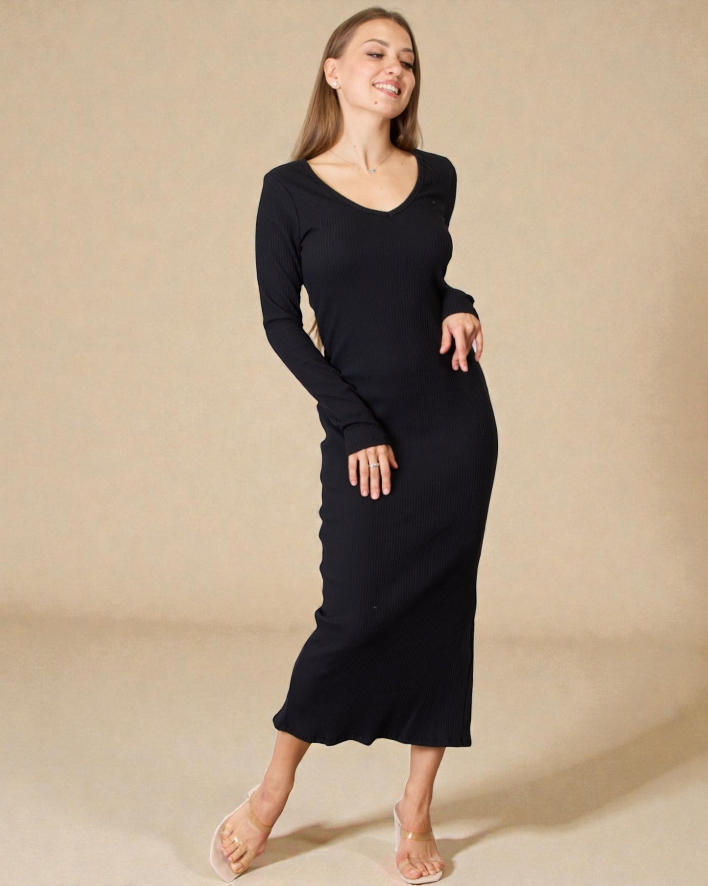 Woman wearing a black long-sleeve dress against a beige background