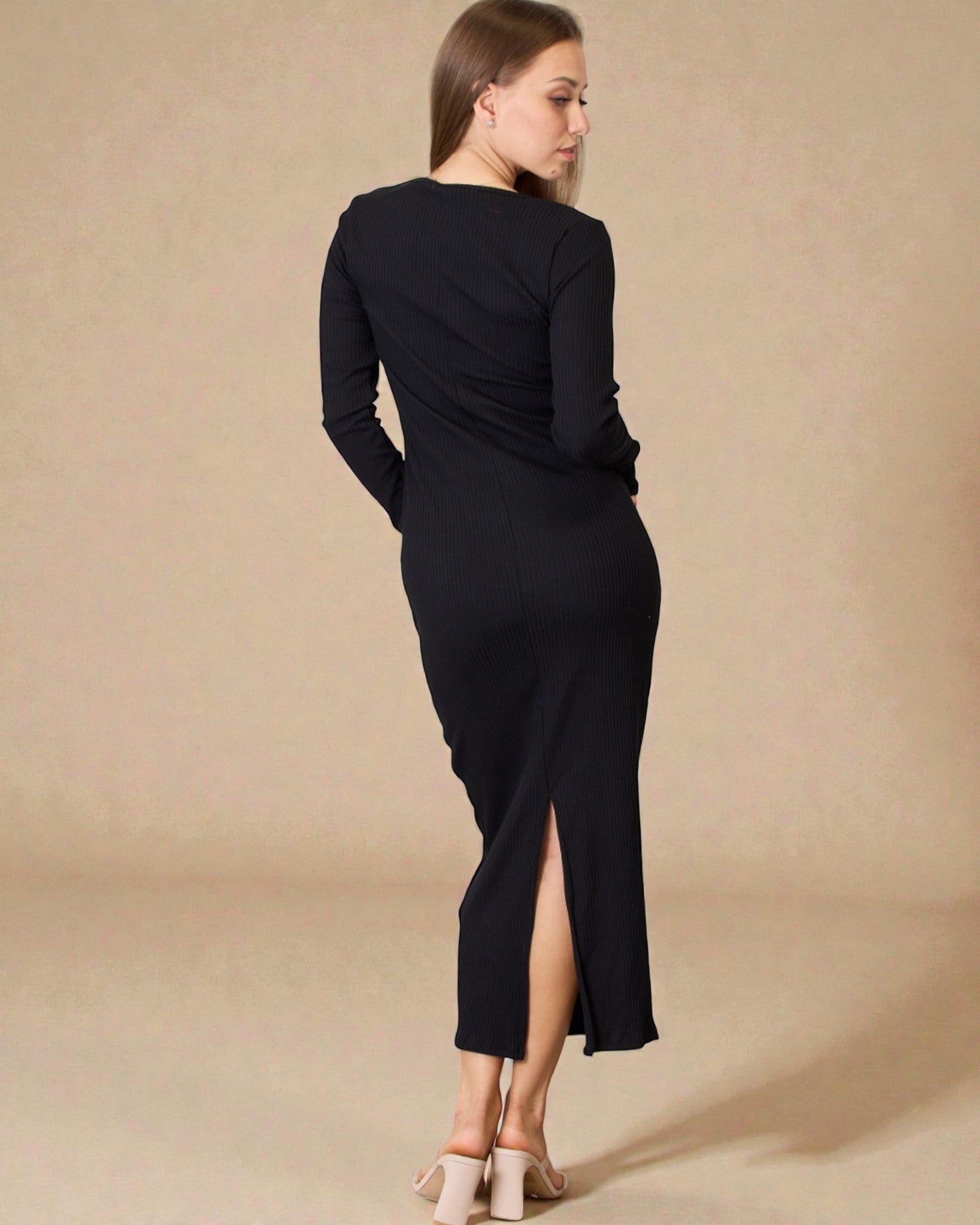 Woman wearing a black dress with a slit on a beige background
