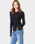 Woman wearing a black long-sleeve top and blue jeans on a white background