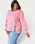Woman wearing a pink sweatshirt and blue jeans on a white background