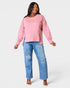 Woman wearing a pink top and blue jeans on a white background