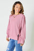 Woman wearing a pink sweatshirt and blue jeans on a white background