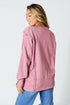 Woman wearing a pink sweater and blue jeans on a white background