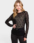 Woman wearing a black sheer long-sleeve top against a white background
