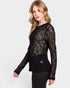 Woman wearing a black sheer long-sleeve top on a white background