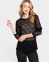 Woman wearing a black sheer top with long sleeves on a white background