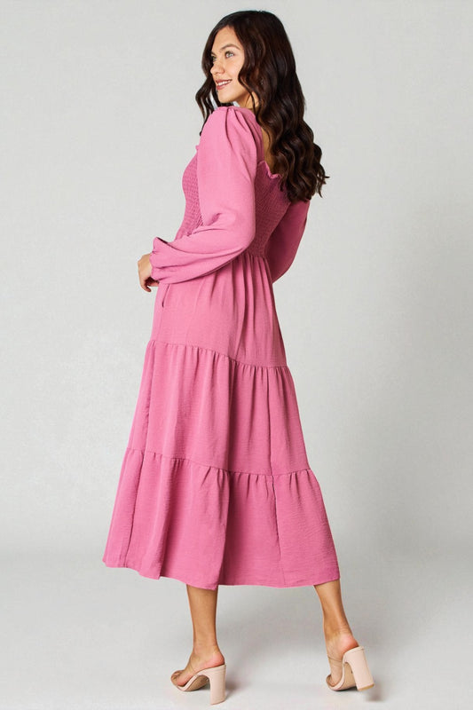 Woman wearing a pink dress on a plain background